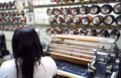 Worker operating fine wire winding machine at Fénix’s production area