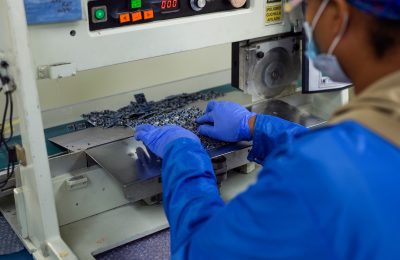 Fénix worker in front of industrial machinery in production plant