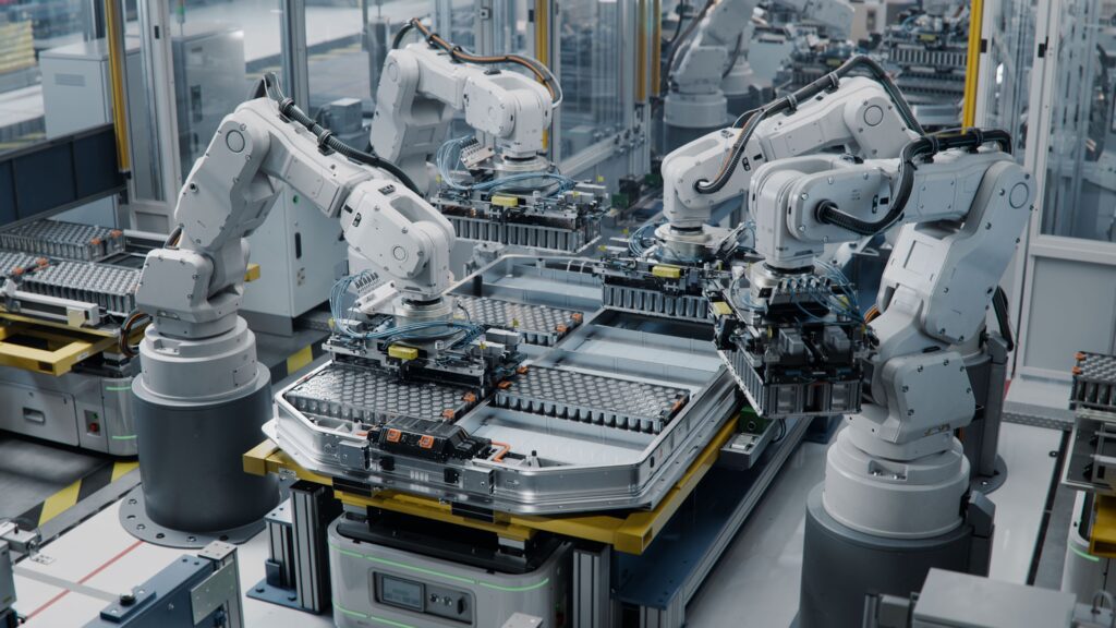 Robotic arms assembling components in an automated facility